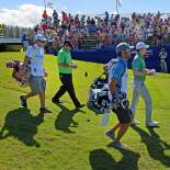 Jordan, Patrick Reed and Caddies Walk Off the First Tee During the First Round